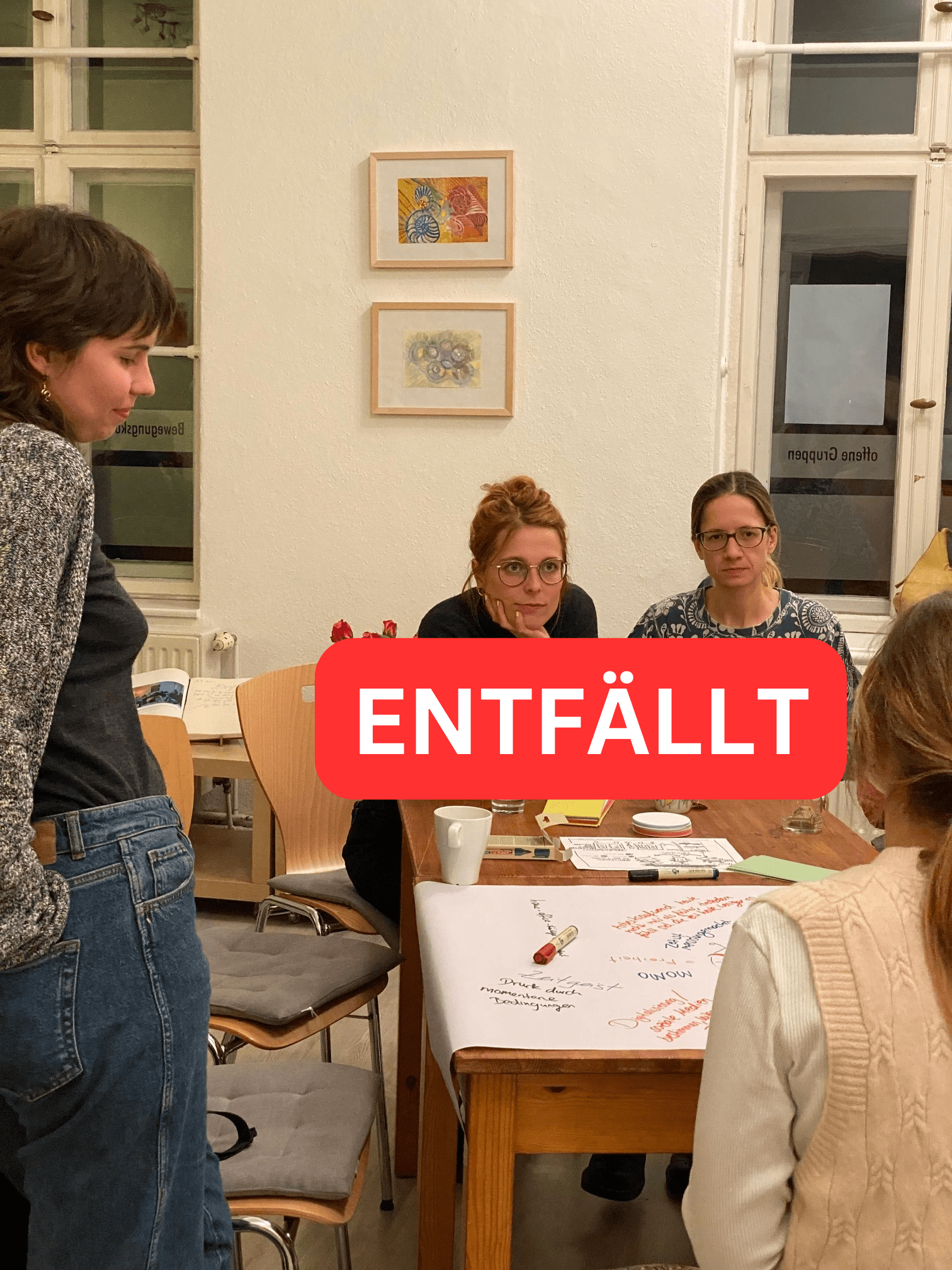 Nachbarschaftsgespräch im Frauenzentrum: 4 Frauen sitzen und stehen um einen Tisch, Bild: Paula Panke